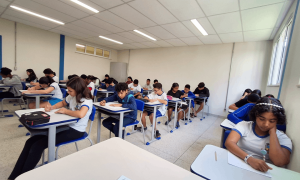 Gráfico de barras comparativo mostrando a redução da distorção idade-série no ensino médio brasileiro entre 2021 e 2025, com destaque para a queda de 25,3% para 16%.