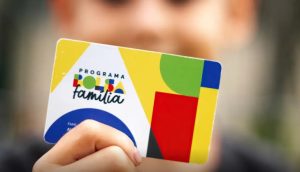 Beneficiário segurando o cartão do Bolsa Família