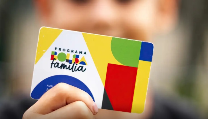 Beneficiário segurando o cartão do Bolsa Família