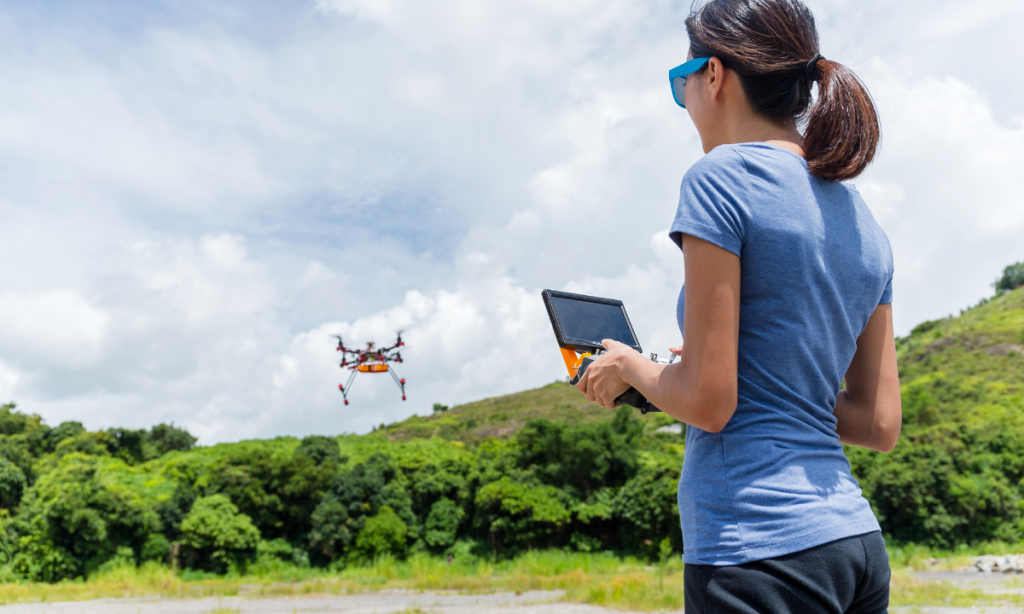 Mulher operando um drone em ambiente aberto.