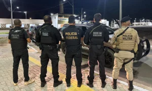 Policiais de diferentes instituições de costas se preparando para operação