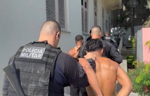 Viaturas da Polícia Militar e da Delegacia de Homicídios estacionadas na Rua Dom Bosco, em Icaraí, com isolamento de fita amarela em torno da cena do crime durante o amanhecer.