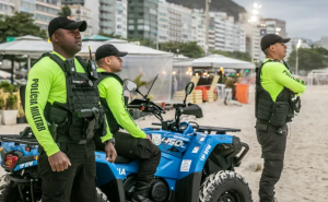 Policiais da Polícia Civil e Militar em patrulhamento na orla de Copacabana durante a realização de um grande evento.