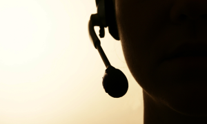 Rosto de operadora de telemarketing com fone de atendimento