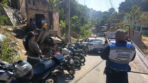 Trio que debochou da polícia é preso em niterói. Foto: Agentes de segurança de costas em meio aos veículos apreendidos